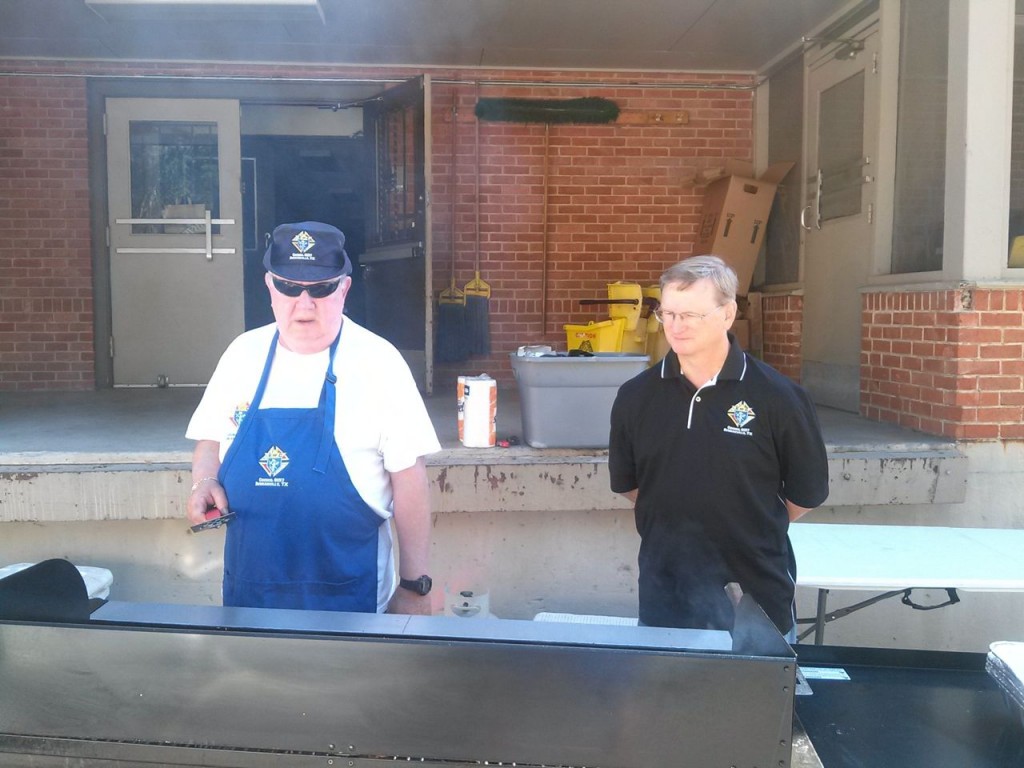 Jim Stavinoha and Doug Karpan at the grill outside St. Joseph's Residence.